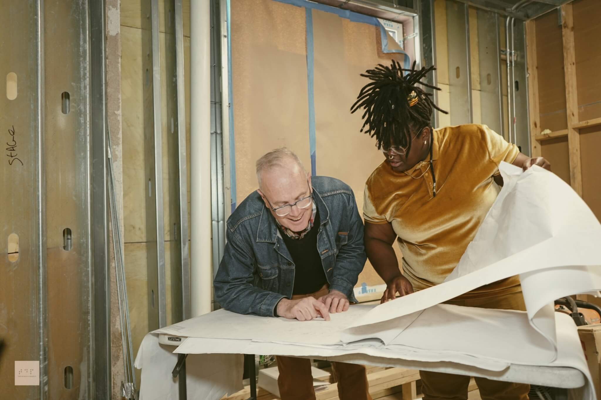 Owners of the bookstore look over blueprints of the space.